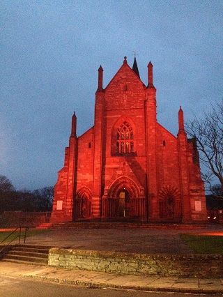 St Magnus Cathedral lit in red.