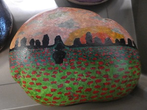 Painted stone showing standing stones and field of poppies.
