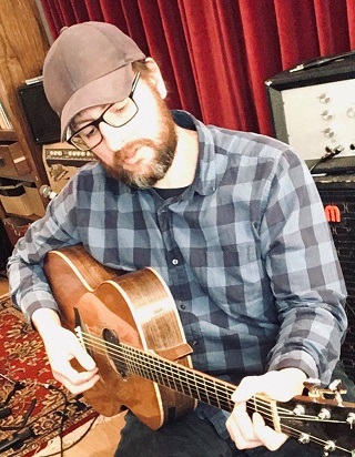 Photo of musician Brian Cromarty playing a guitar.