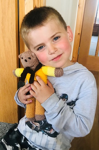 One of the nursery bairns, Kian, with one of the SWI teddy bears.
