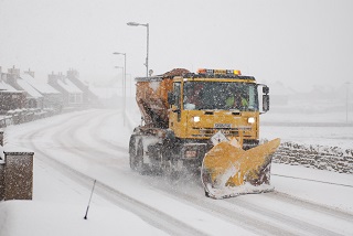 Photo of an Orkney Islands Council gritter in action.