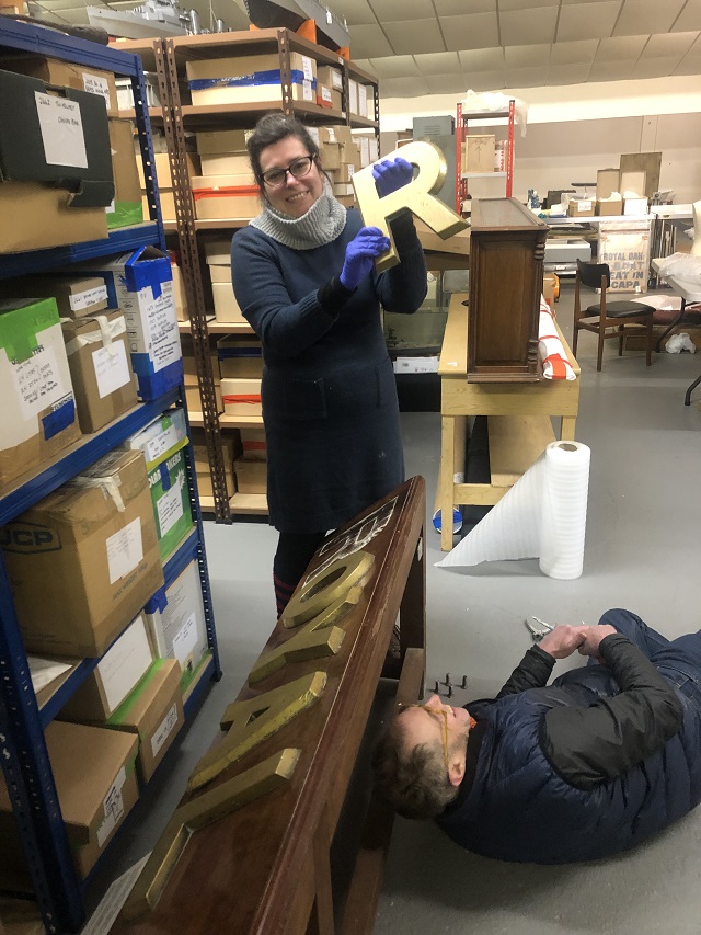 Mountmakers Colin Lindley and Kate Silverston at work in Orkney Islands Council’s Museum’s stores, removing the Royal Oak letters from their previous mount in preparation for refreshed display when the Scapa Flow Museum reopens in summer 2022.