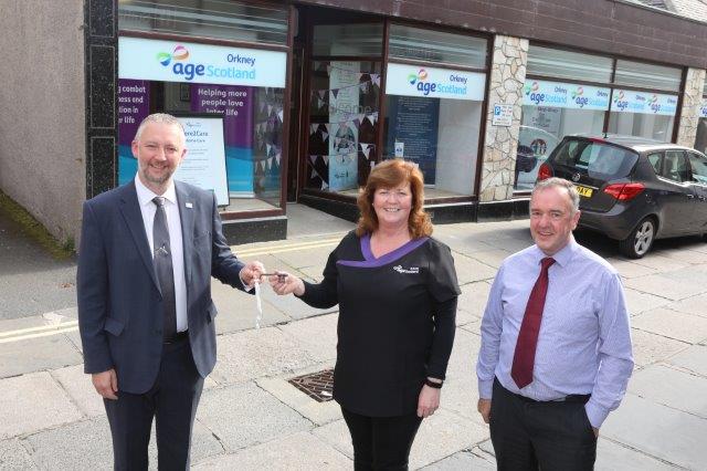 a woman and 2 men stood outside age concern