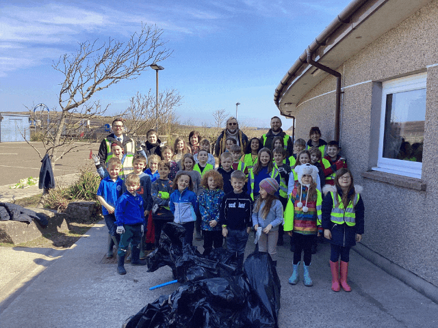 children collecting rubbish and bagging it into black bags