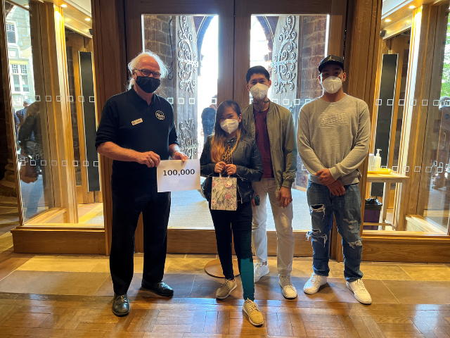 3 people standing inside the cathedral stating that they were the 100000 visitor