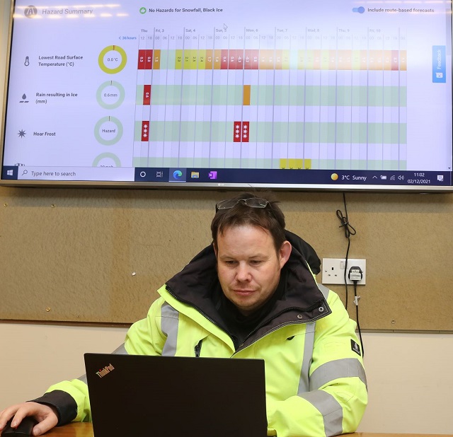 A man sitting at a desk working on a laptop