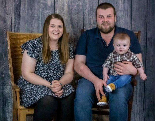 a lady, a man and a baby sitting on his new