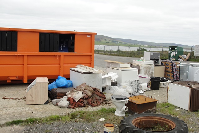boxes and rubbish sitting at a skip entrance