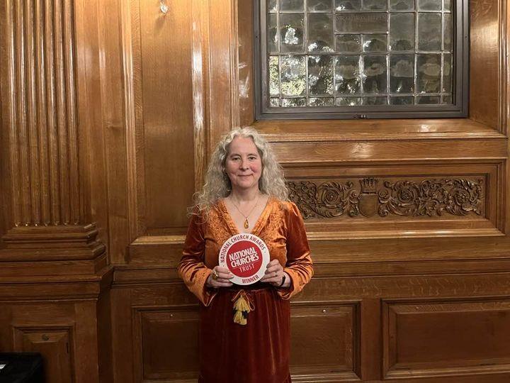 A lady holding an award