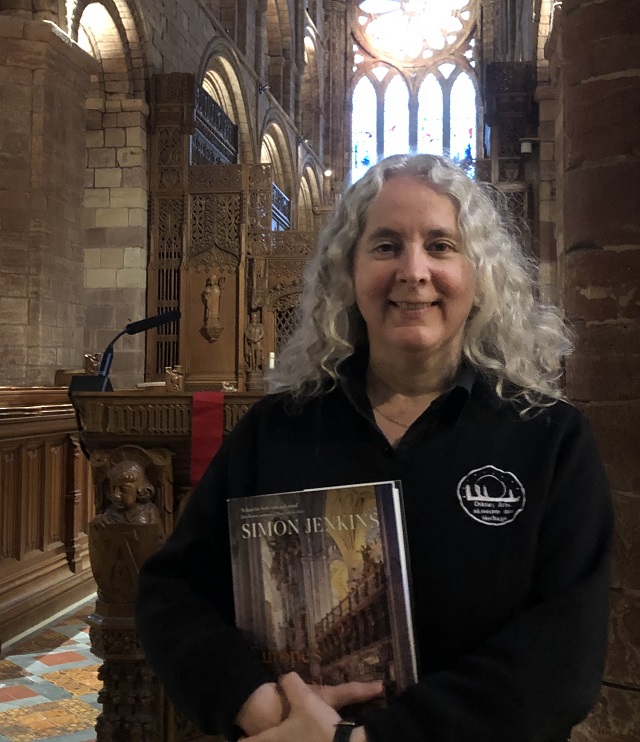 a lady holding a book in the cathedral