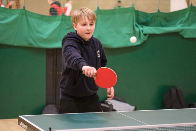 a young boy playing ping pong
