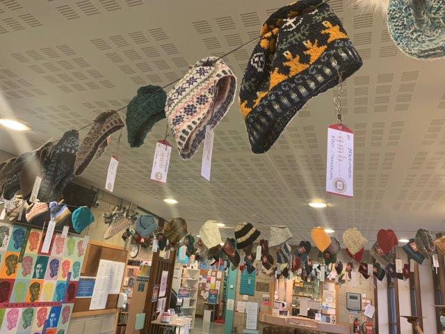hats hanging up around a room for an auction