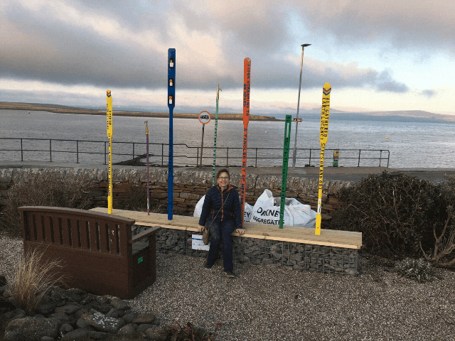 a boy standing in front of 4 colourful posts