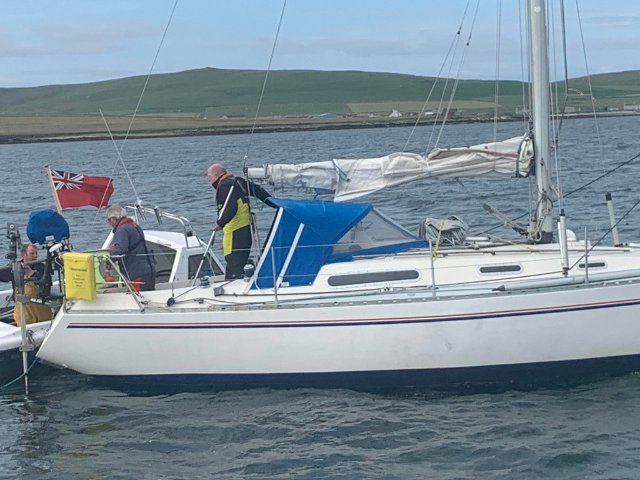 a small boat in the water with 3 people onboard