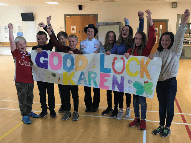 children punching the air and holding a banner saying good luck karen