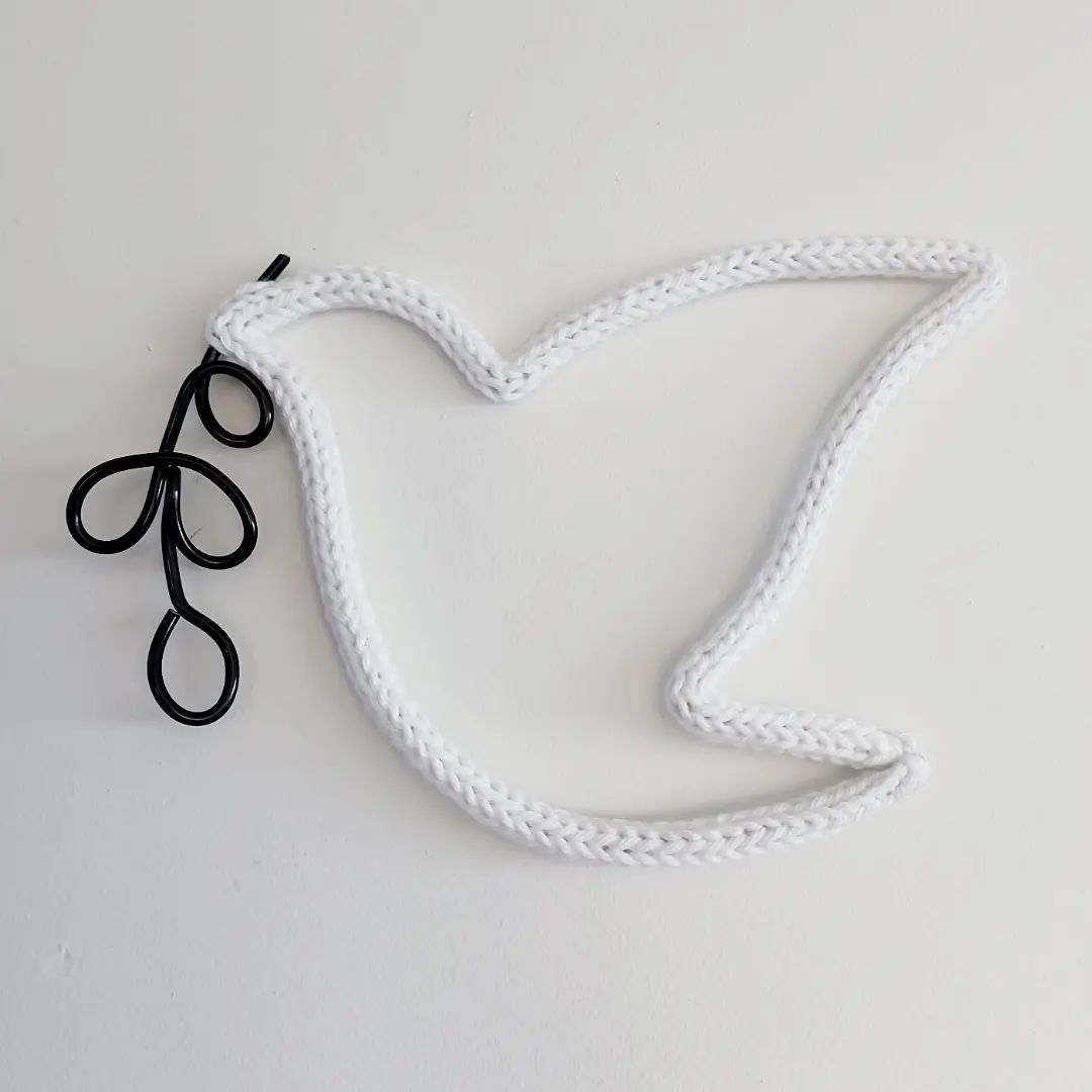 woven dove holding black flower