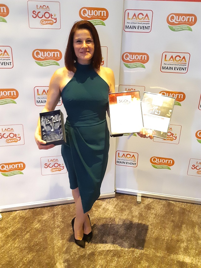 a woman holding an award and certificate