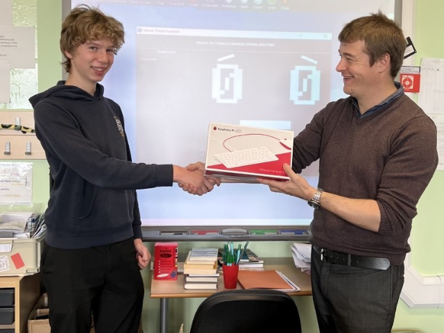 a man shaking a young persons hand handing over a prize