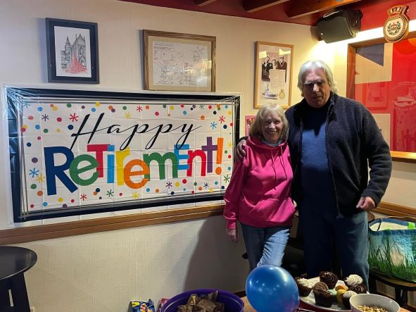 a lady and a man in front of a retirement poster