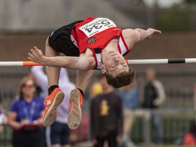 a young boy doing high jump