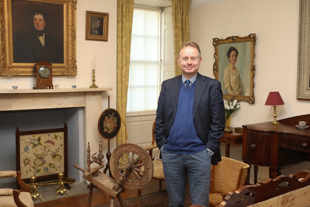 man standing in a lounge with paintings on the walls