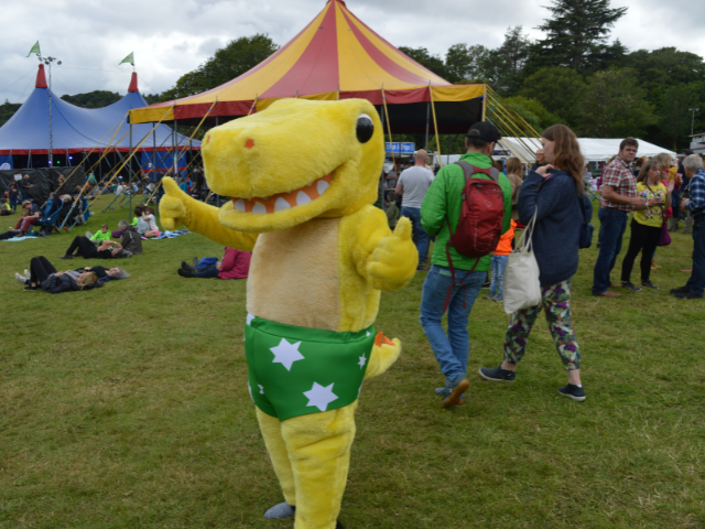 a yellow dinosaur with green pants with white stars on them