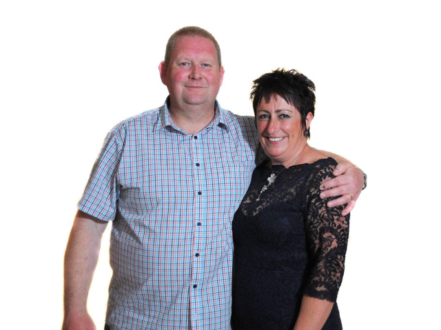 a man smiling with his arm around a woman