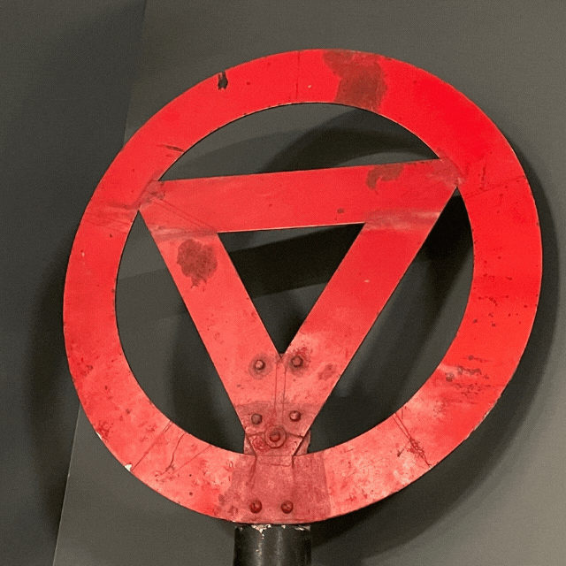 red circle with red triangle inside it with a black background