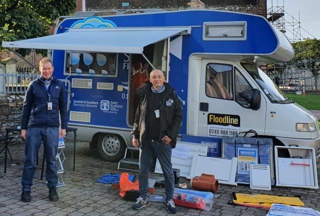 2 men in front of a floodline van