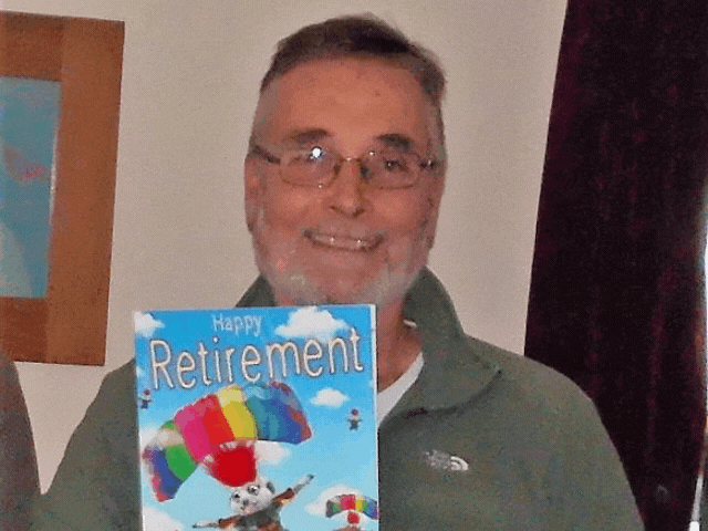 A man holding his retirement card