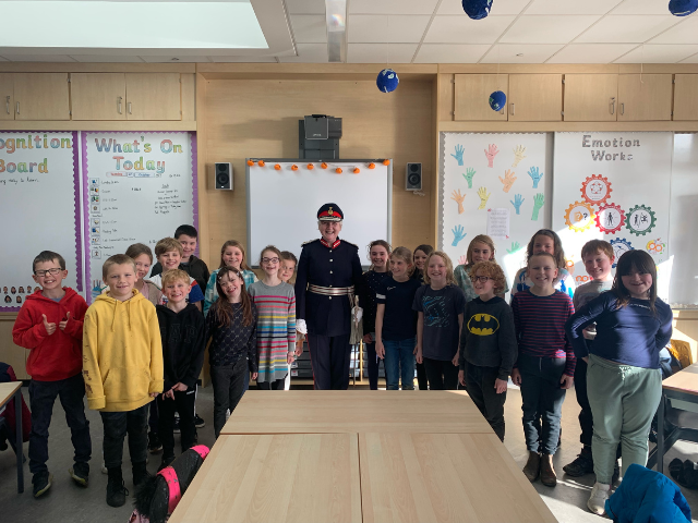 A group of school children in a classroom with the Lord Lieuentant