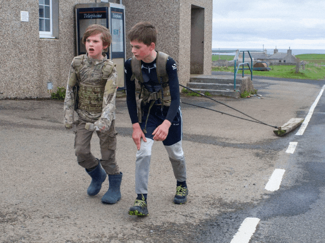 2 young boys pulling a log