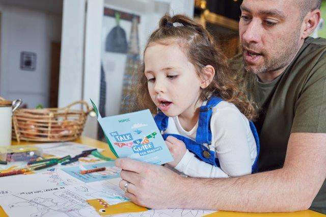 a man reading to a little girl