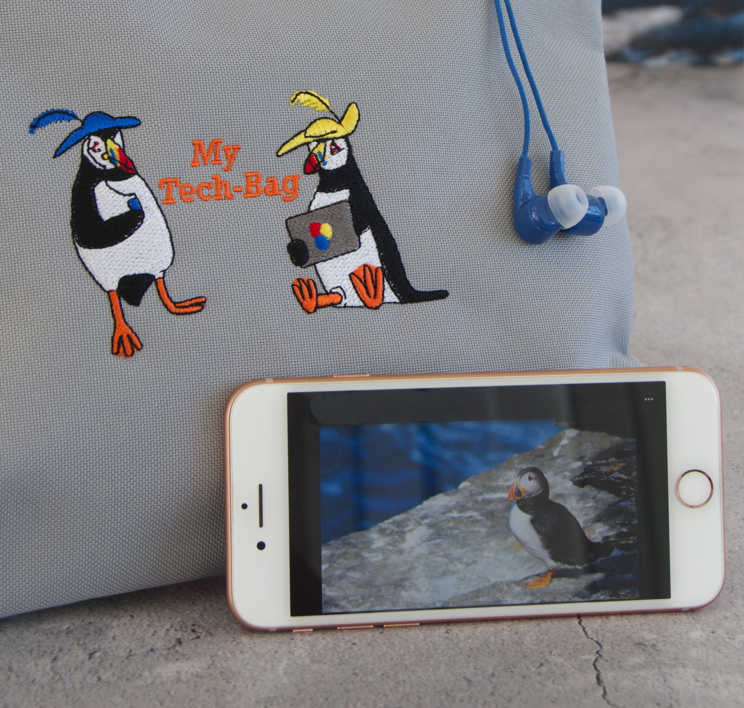 2 puffins printed on a bag with a phone next to it with a puffin photo on it