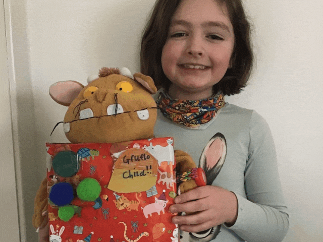 a young girl holding a Gruffalo toy