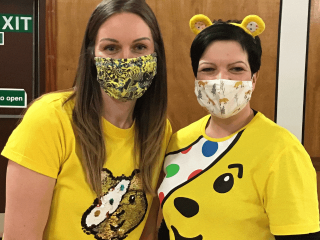2 ladies with face masks on dressed up for children and need