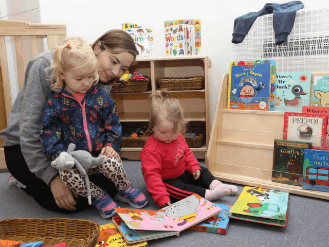 A lady reading two small children a story